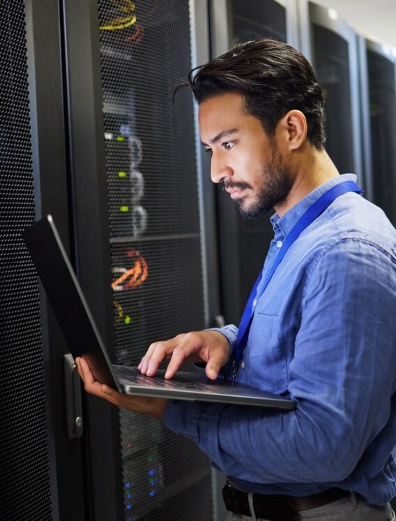 man using computer in server room